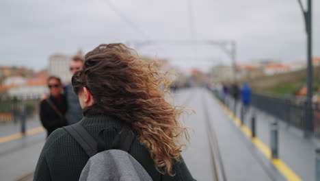 mujer con una mochila caminando por un puente