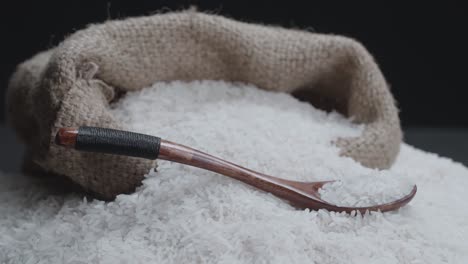 closeup gunny bag of rice seeds rotating slowly over black background.