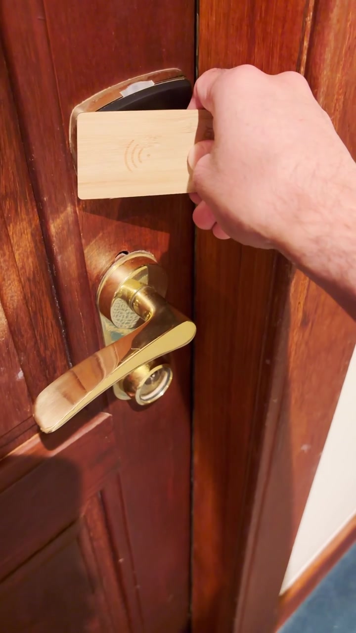 Video verticale in POV di una persona che apre la porta di una camera d'albergo con una keycard. Mano che usa la tessera per sbloccare ed entrare nella suite durante una vacanza o un viaggio di lavoro. Reel in stile contenuto generato dall'utente con punto di vista.