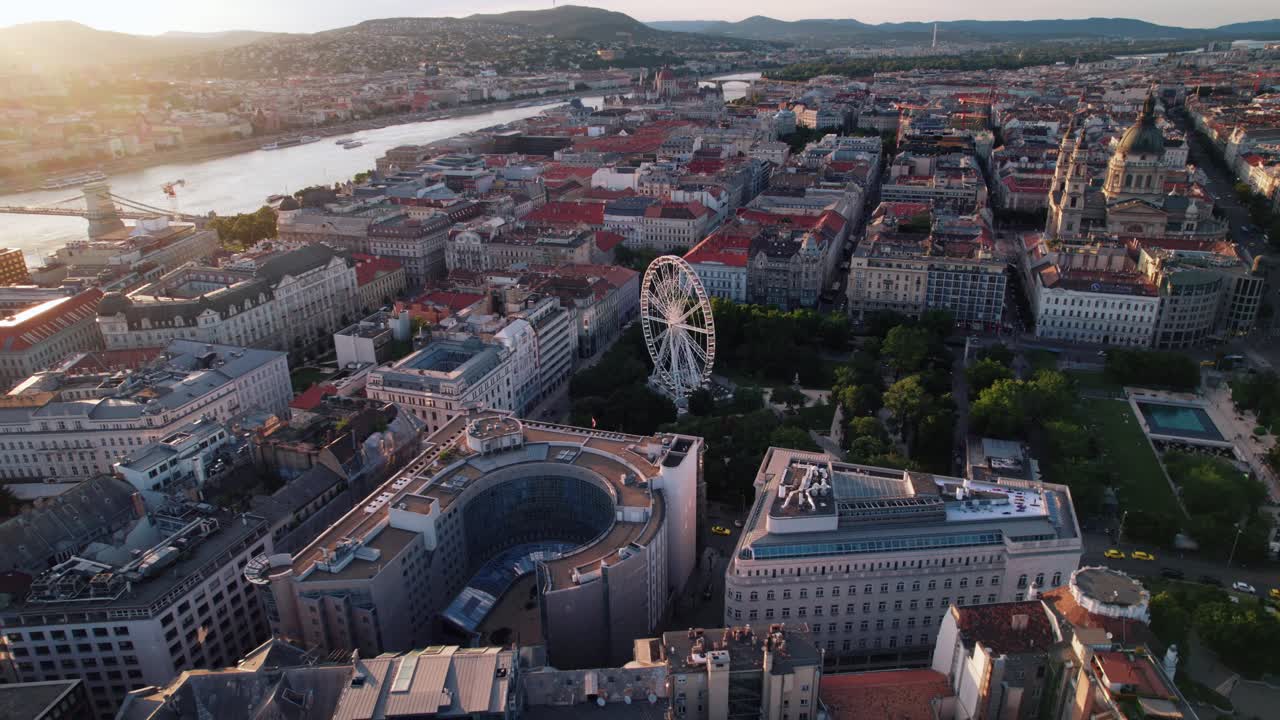 Budapest con i suoi monumenti iconici, la ruota panoramica e il fiume all'ora d'oro, vista aerea.