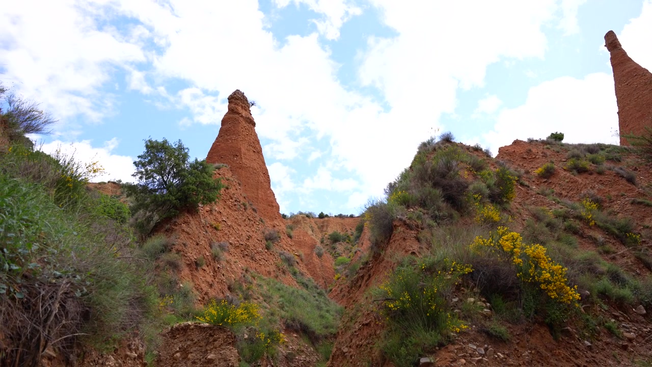 Las Carcavas, rocce rosse frastagliate viste dal basso, prospettiva unica con panoramica verso sinistra. Camini delle fate