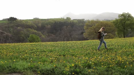 mochiler con aplicación de navegación en el teléfono inteligente caminando en el campo rural