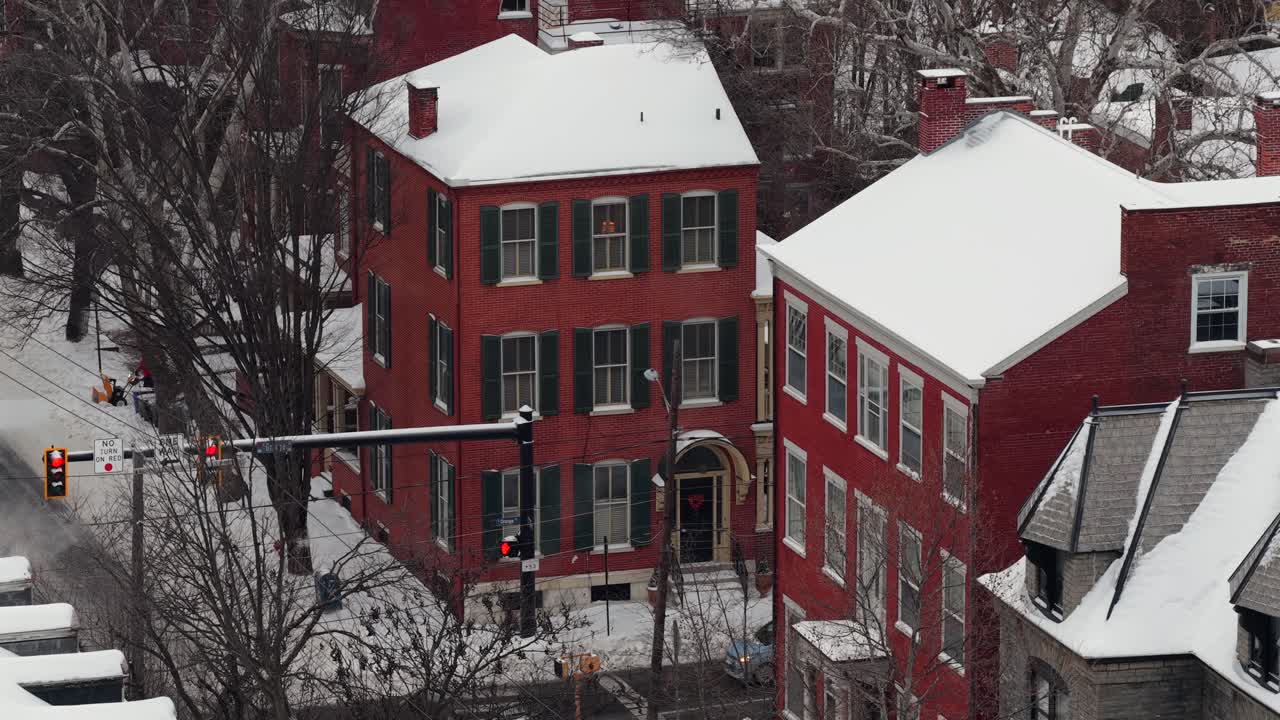 Luftfoto af røde murstenslejlighedshuse i Lancaster, Pennsylvania, dækket af frisk sne om vinteren med klassisk amerikansk boligarkitektur. Nedstigningsskud.