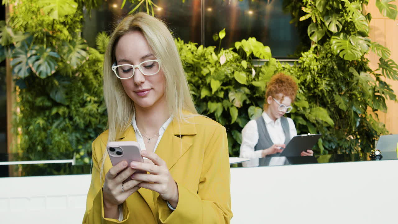 блондинка использует смартфон в отеле