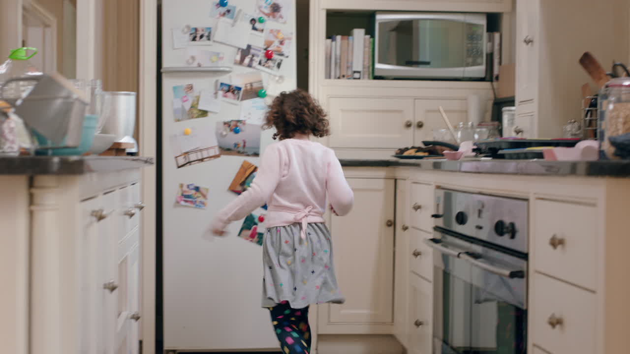 niña feliz bailando en la cocina divirtiéndose haciendo movimientos de baile divertidos disfrutando del fin de semana en casa