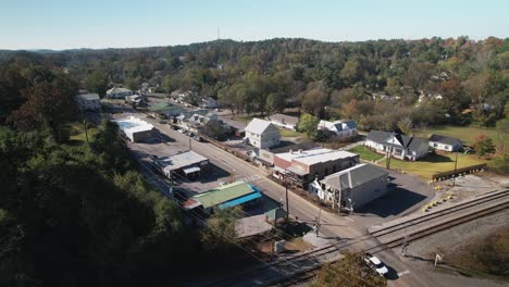 aerial pan of small town shops and eateries surrounded by scenic views in old town helena, alabama
