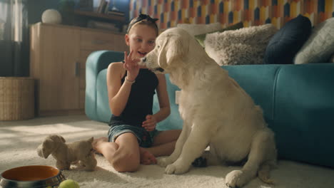 girl playing with puppy in living room