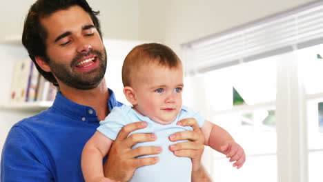 -Padre-Feliz-Jugando-Con-Un-Lindo-Bebé