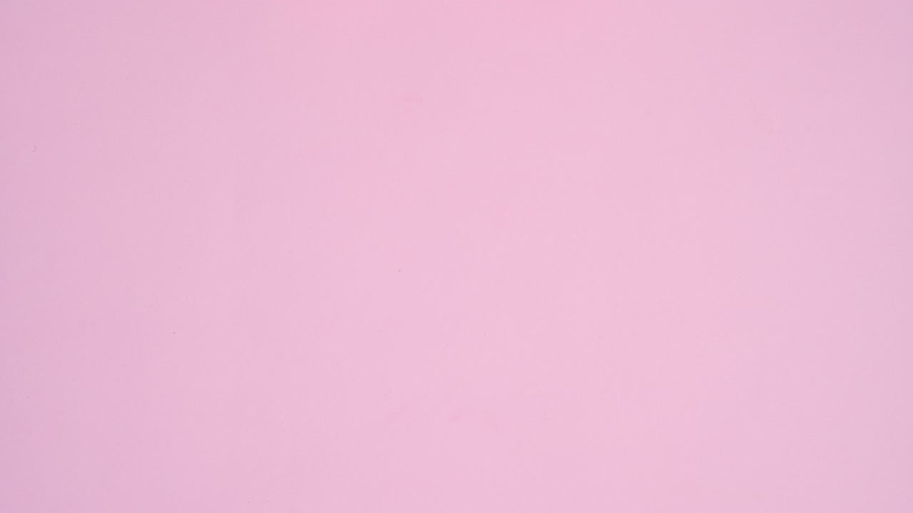 Colorful candies, sweets, lollypops, chocolates appear on pastel pink theme. Stop motion flat lay