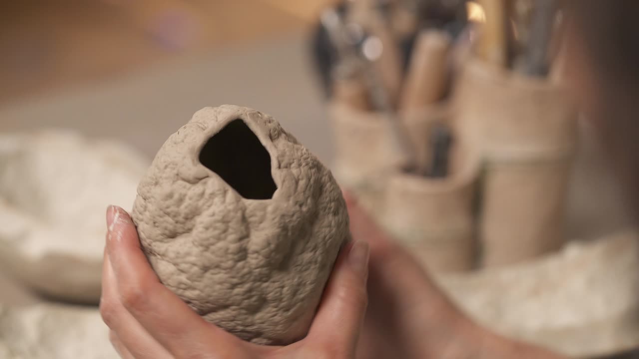 여성의 손이 도형화하고 모양을 는 오벌 모양의 조각. 스튜디오에서 일하는 예술가. 취미와 직업 개념.