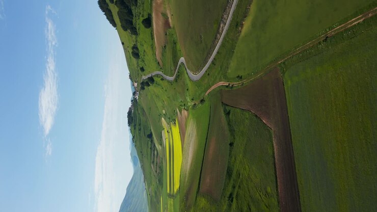 Spettacolare ripresa aerea verticale con drone del paesaggio rurale di Norcia con strade tortuose e campi aperti durante il giorno