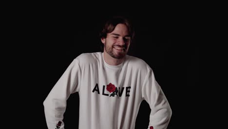 trendy young man laughing at camera, happy gesture, wide, black background