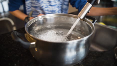 filling up a large pot with water in slow motion