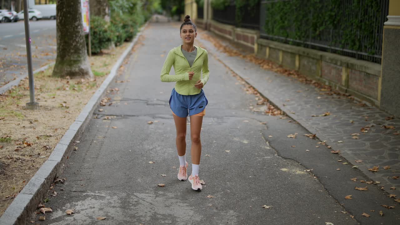 mujer corriendo por la calle de la ciudad en otoño