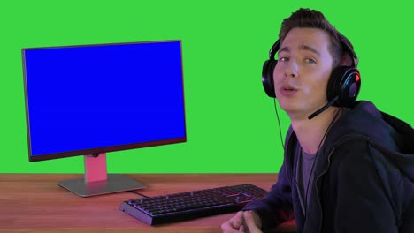 녹색 화면, 크로마 키에 pc 모니터 에 앉아있는 카메라와 대화하는 게이머