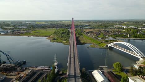 vehicles driving on third millennium john paul ii bridge over martwa wisla river beside railway bridge in gdansk, poland