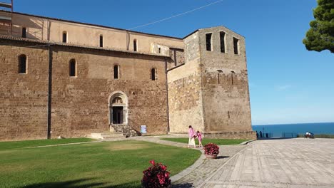 Mother-and-daughter-walk-towards-entrance-of-San-Giovanni-in-Venere-Abbey