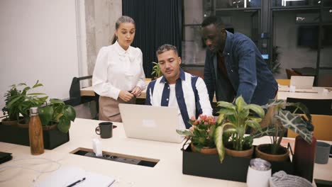 multiracial colleagues browsing laptop together