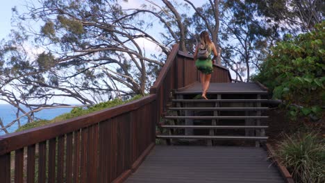 girl in beach dress walking barefoot on the wooden viewing platform