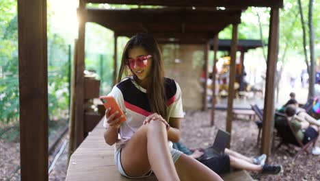 woman using a mobile phone in a park cafe