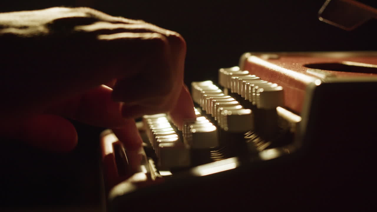 Primo Piano di Mani che Scrivono su una Macchina da Scrivere d'Epoca con Luce Drammatica