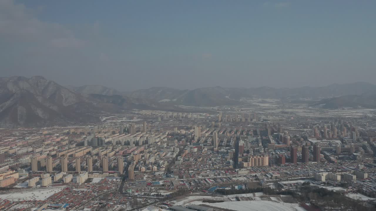 Super high and wide aerial shot of an industrial Eastern Communist Bloc city during the winter. 4K