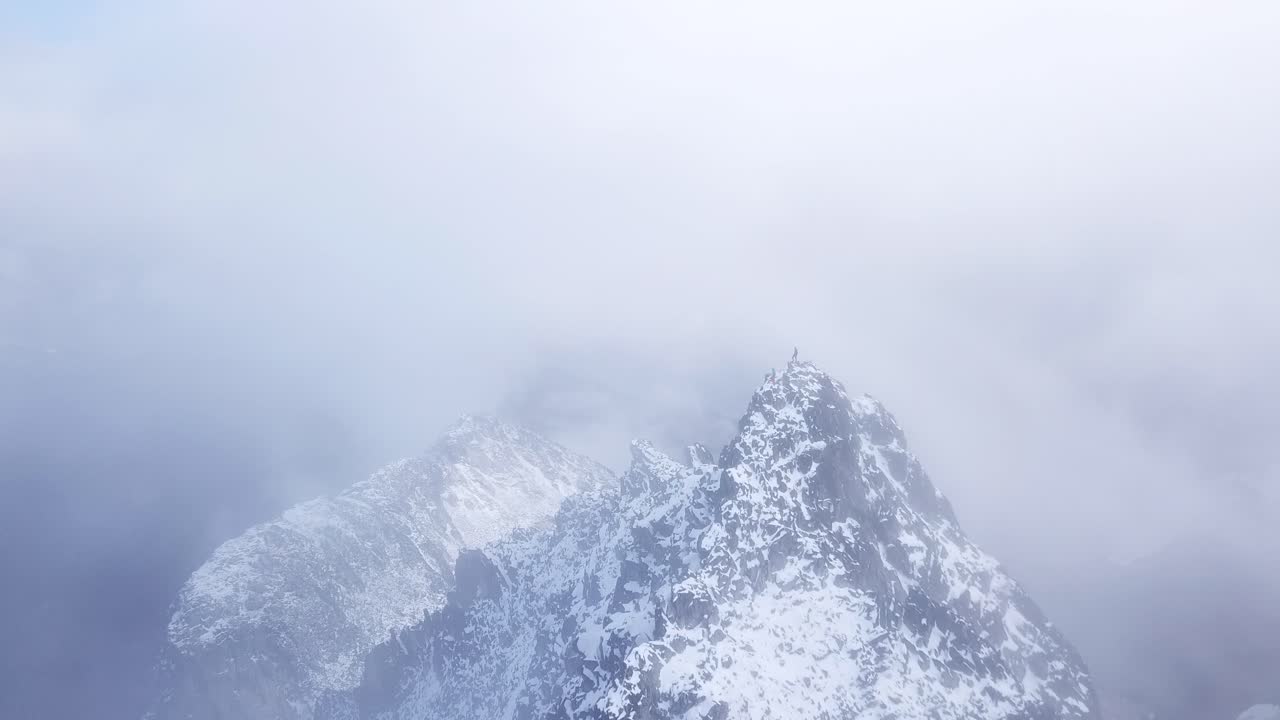 Hikers standing on top of a cloudy peak in the coast mountains of Canada