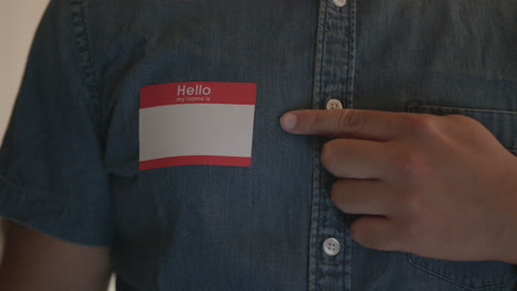 Close-Up-of-a-Man-Pointing-to-a-Blank-Name-Tag