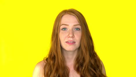 shocking redhead woman screaming with open mouth on yellow background