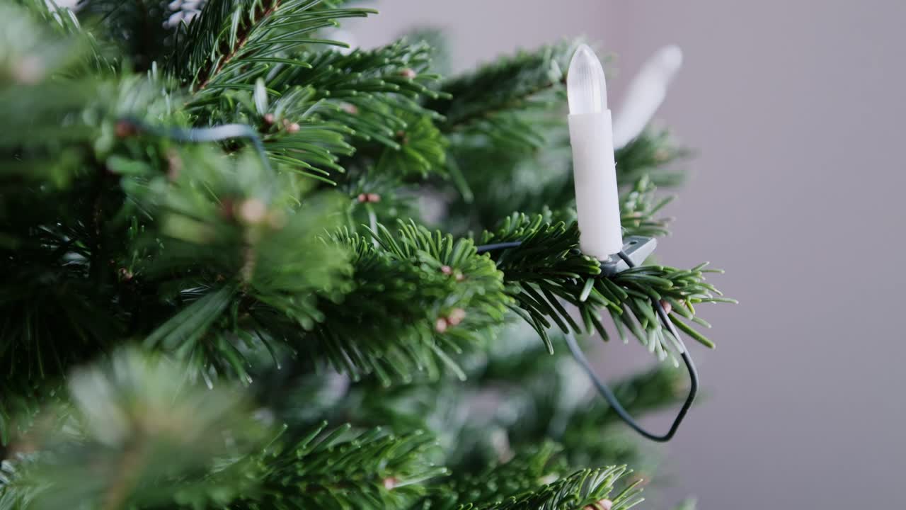 Close-up of an unlit LED candle attached to a Christmas tree. Subtle parallax movement reveals needles and texture, creating a quiet, restrained, and traditional mood