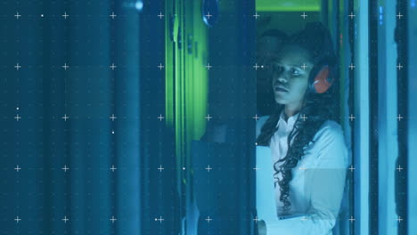 Analyzing data with digital overlay, woman wearing headphones in server room