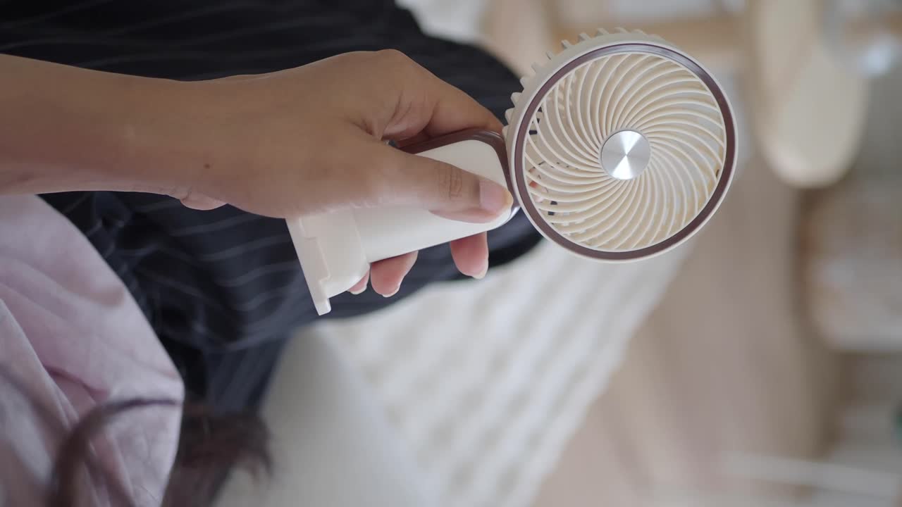 Hand holding a portable fan
