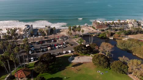 Aerial-fly-over-of-a-park-going-to-a-private-beach-with-homes