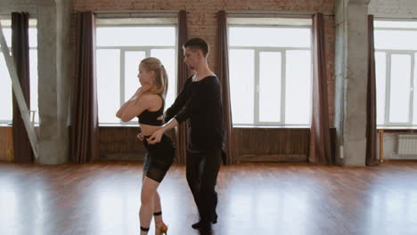 a couple performing ballroom dance moves in a studio