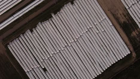 Aerial-top-down-of-harvest-covered-with-silo-bags-on-agricultural-farm-field---4k-drone