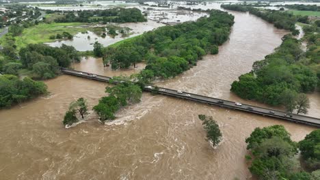 Coches-Circulando-Por-El-Puente-Del-Río-Barron-En-Caravonica-Con-Grandes-Inundaciones-En-Cairns,-Australia