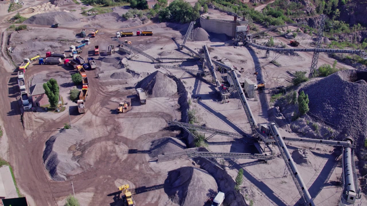 Quarry site with heavy machinery and transport equipment in action