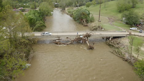 man clearing debris from fallen tree on bridge after historic flooding from hurricane helene in western north carolina september 2024