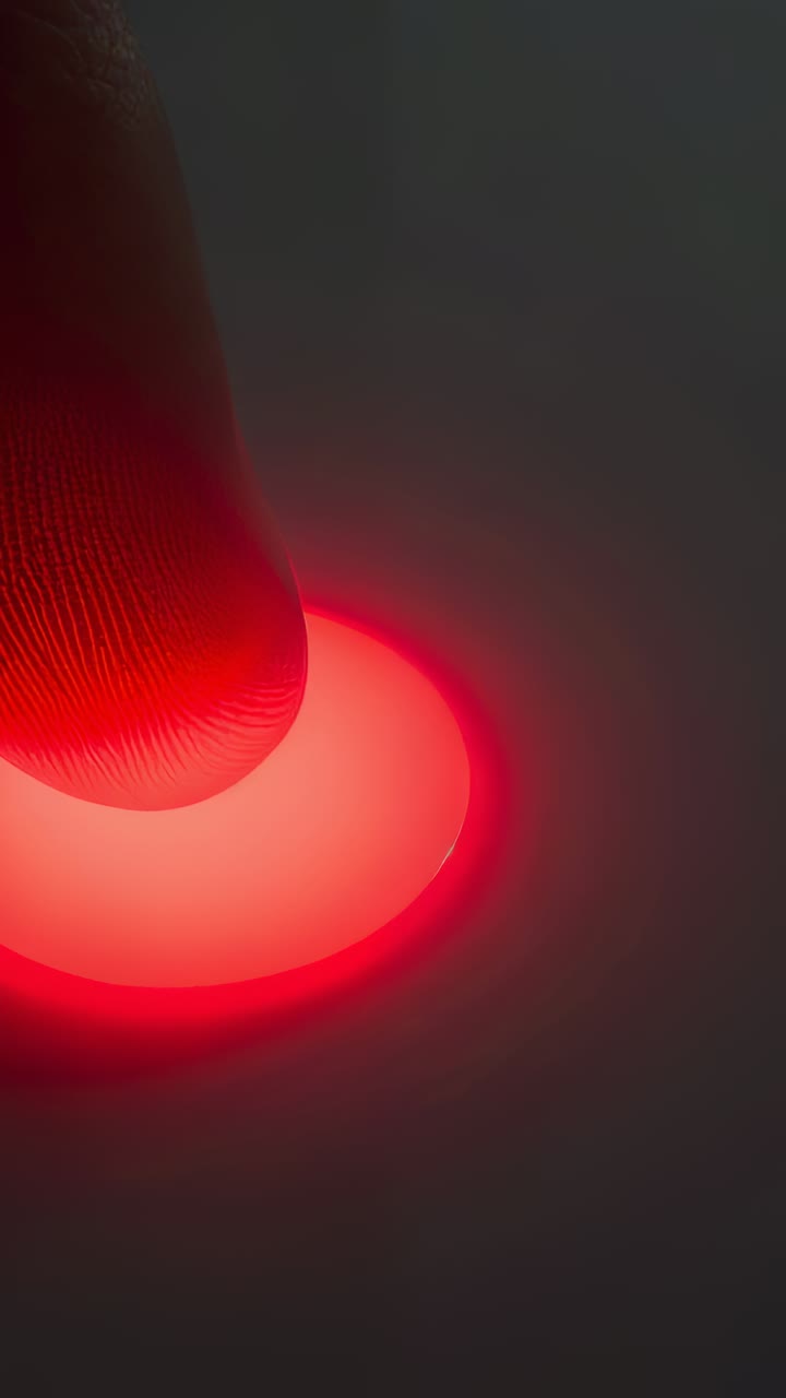 Vertical video: Pressing fingertip activating red pad on panel, lighting white beam and dust