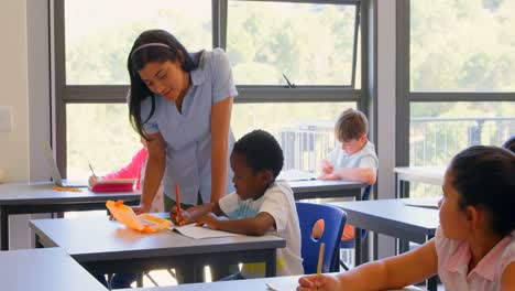 Female-teacher-explaining-schoolboy-in-the-classroom-at-school-4k