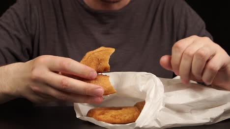 man taking doughnuts and eating doughnuts