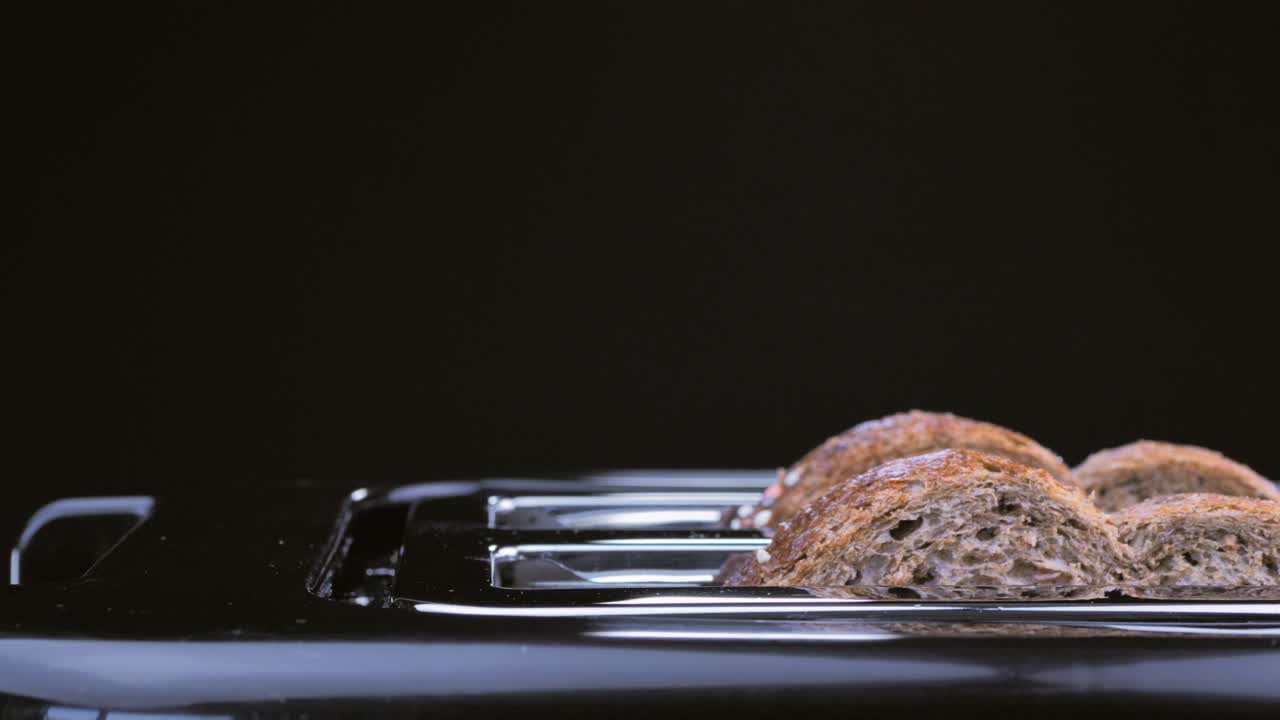 Roasted bread popping up from a steel toaster