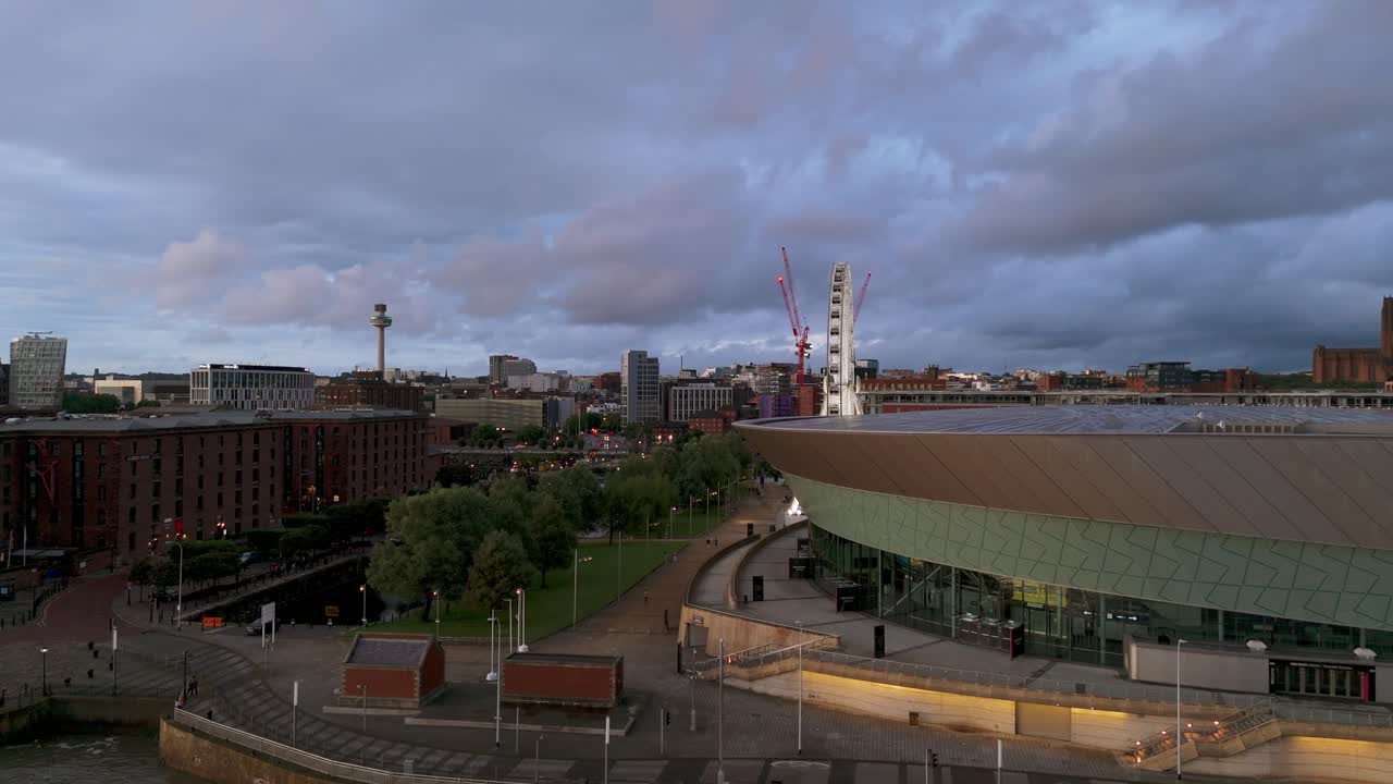 Aerial view of Liverpool's historic Royal Albert Dock and modern M and S Bank Arena under a dramatic sunset sky