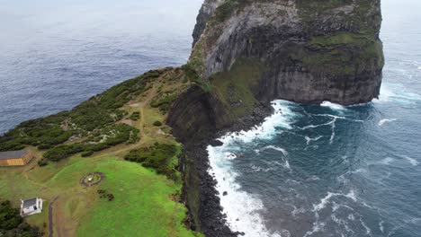 aerial tilt up shot reveals morro de castelo branco being crashed by atlantic ocean waves