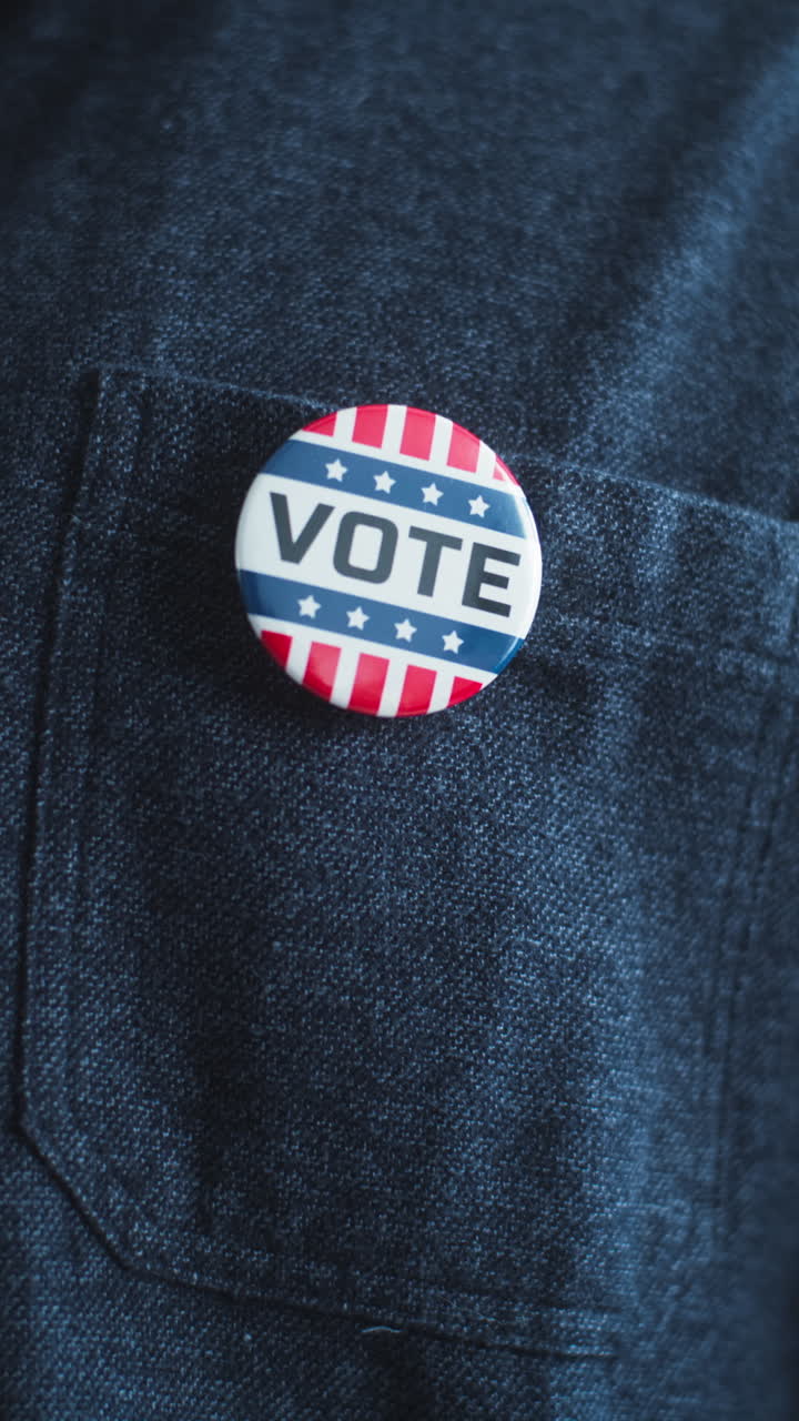 African American Man Puts on Badge with Usa Flag Logo and Inscription i Voted Anonymous African American Man Puts on Badge with Usa Flag Logo and Inscription i Voted us Citizen at Polling Station during Elections National Election Day in United States of America Close up