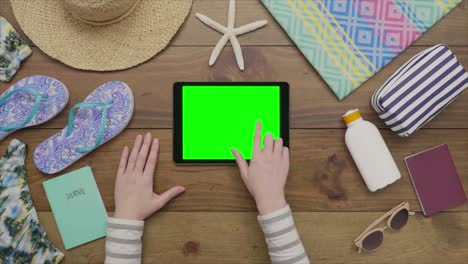 aerial footage of woman using tablet computer by beach supplies