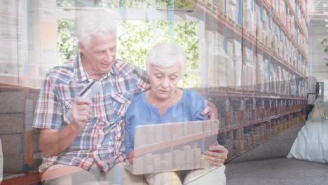 pareja de ancianos caucásicos en distanciamiento social comprando en línea en casa