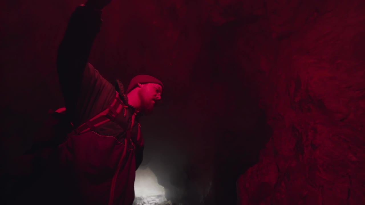 explorador en una cueva con humo rojo
