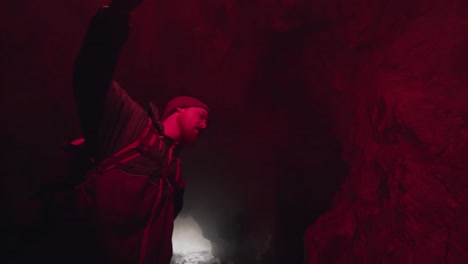 explorer in a cave with red smoke