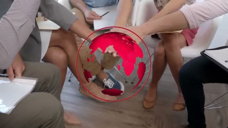 Animation-of-red-globe-rotating-over-diverse-colleagues-stacking-hands-at-casual-office-meeting